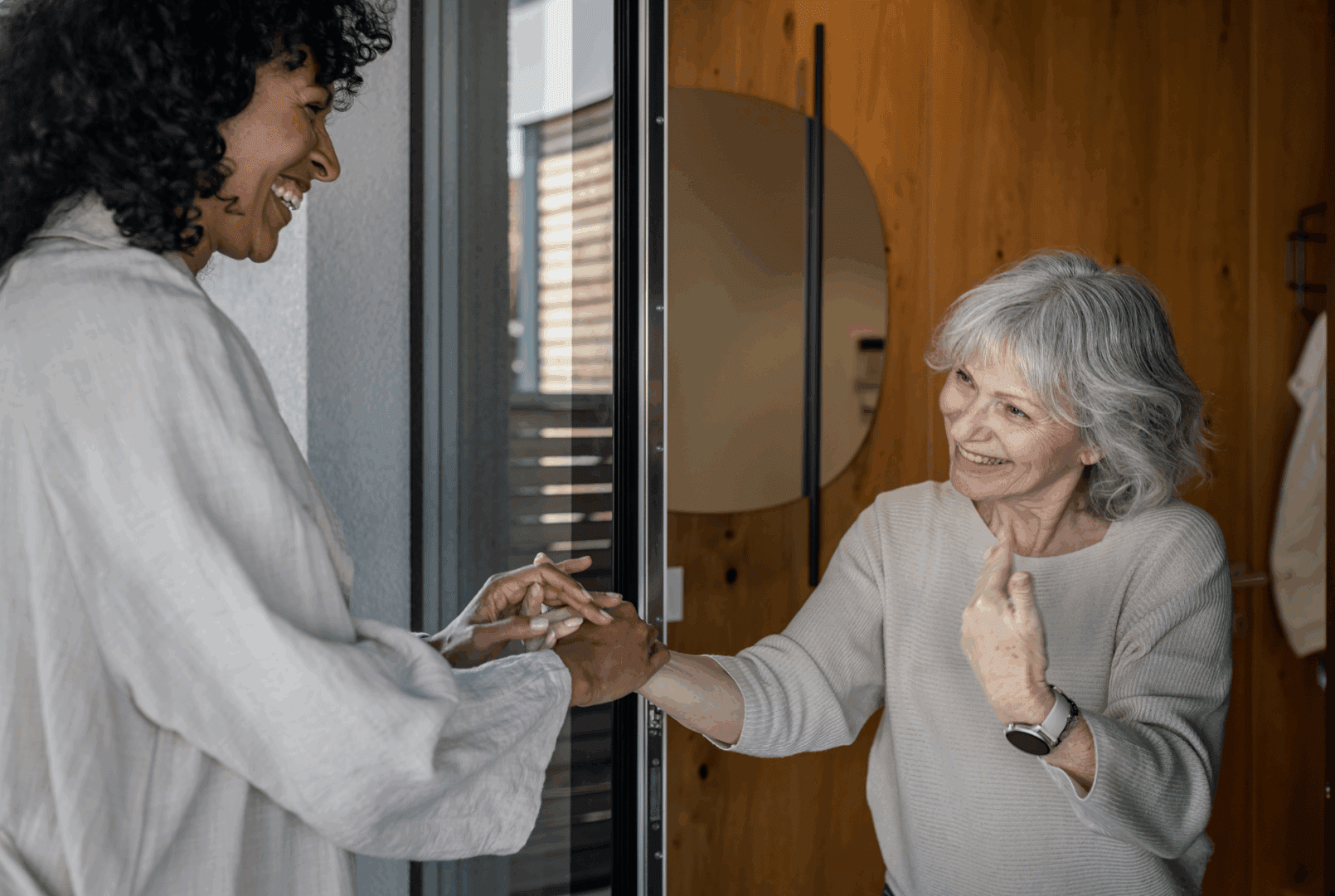 Two women smiling and holding hands indoors. Two women smiling and holding hands indoors.