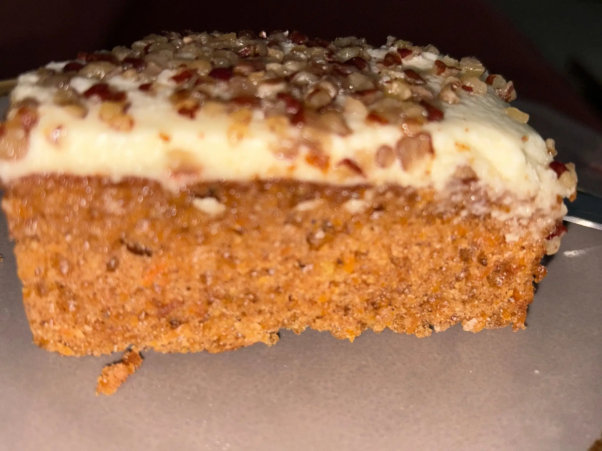 Carrot cake slice with cream cheese frosting.