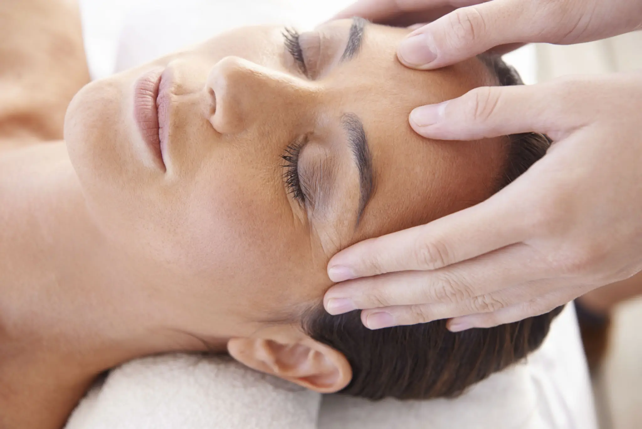 Woman receiving a relaxing facial massage.