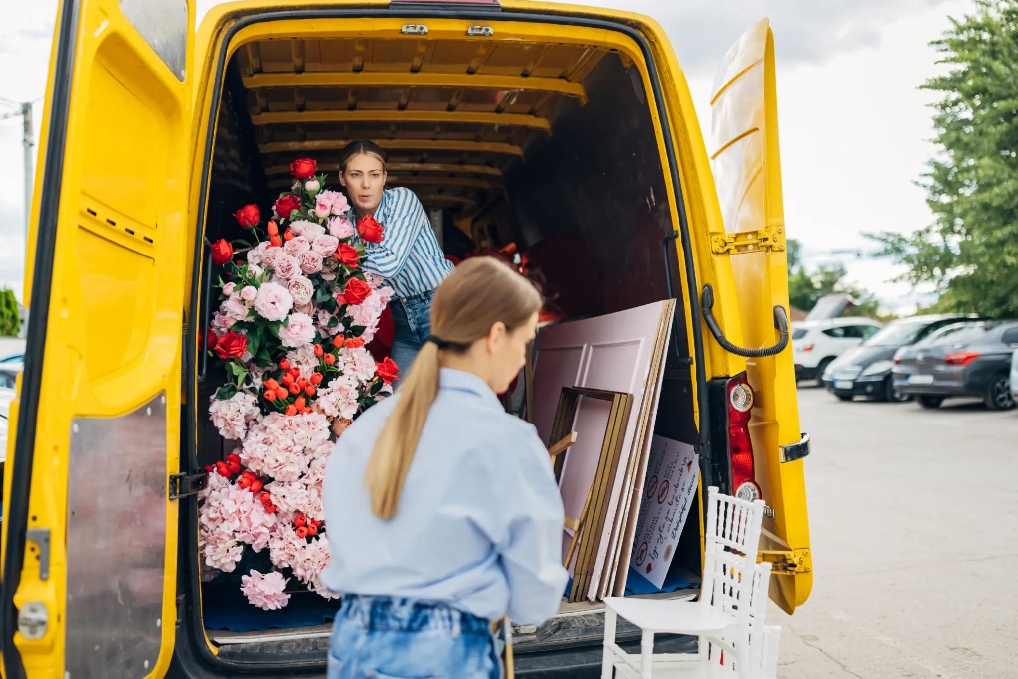Yellow van with flowers and frames inside.
