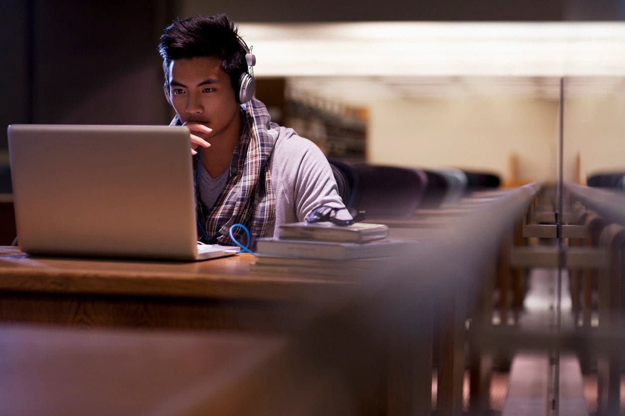 Person studying on laptop in library.