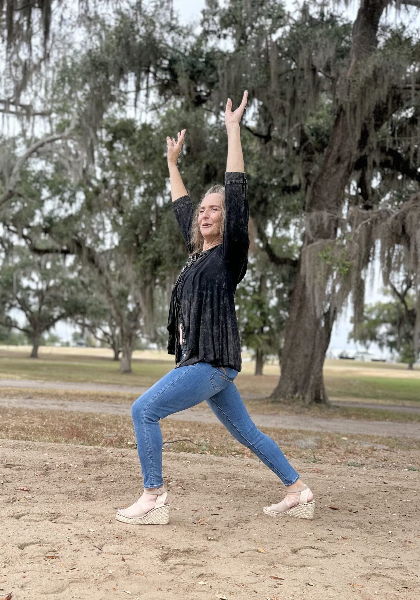 Woman posing enthusiastically in a park.